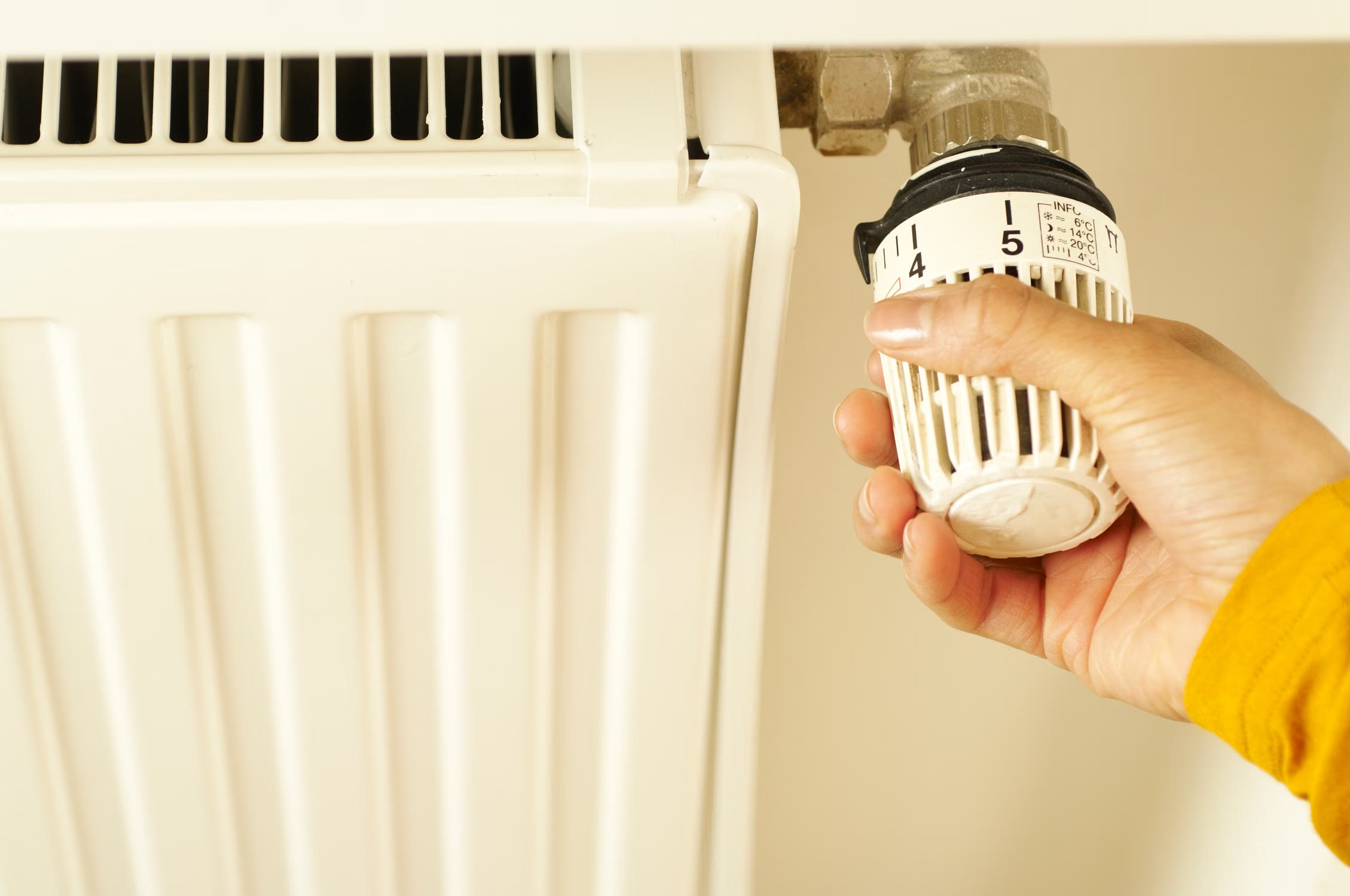 Persona ajustando el termostato de un radiador
